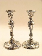 A pair of silver candlesticks sold