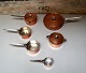 Henning Koppel: "Taverna". 6 pots in copper, inner sides coated with silver. 
Handles in steel.
Manufactured and stamped by Georg Jensen Design.