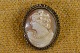 Cameo lady with 
pearl necklace 
off cut conch, 
mounted in 
finely 
decorated 
silver frame 
...