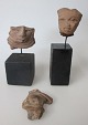 Collection of three ancient South American clay figurines with faces. Two mounted on a base. H: ...