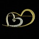 F. Hingelberg. 
'Heart 
Crusher'. 
Diamond brooch 
set with a 
heart-cut 
diamond 0.35ct 
and ...