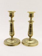A pair of French empire brass candlesticks