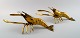 Two brass table decorations in the shape of lobsters.

