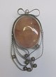 Polished amber 
brooch, 20th 
century. With 
silver 
filigran. 
Stamped. 
Height: 5 cm.