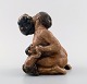 Ceramic Figurine of a kneeling woman with fauns and a bunch of grapes, from the 
series Grape harvesting.
Signed Kai Nielsen 1912.