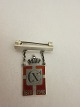 Royal batch made of Sterling silver 925S with red 
enamel motif of the Dannebrog
This batch is made as a brooch with a beam
Year 1870-1940 is on as well as Christian X
The Silver smithy of Georg Jensen produced it in 
1940-47