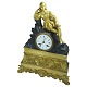 A French clock of gilt bronze, neo-rococo.Watch in brown patinated bronze with a lying man. ...