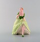 Art deco Royal Dux håndmalet porcelænsfigur. Kvinde i lysegrøn kjole med 
strutskørt. Tjekkiet, 1940