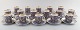 Esteu Tomula for Arabia. Sæt på 16 "Iiris" mokkakopper med underkop. 
Guldblomster på lilla baggrund. 1960/70