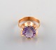 Swedish goldsmith. 18 carat gold ring adorned with purple semi precious stone.