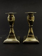 A pair of brass candlesticks on square foot sold