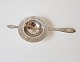 Empire tea 
strainer in 
silver 
Stamped the 
three towers 
1903 
Length 19 cm.