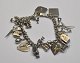 Iron bracelet, 
USA, 20th 
century with 20 
charms. L: 16 
cm. Several 
charms in 
sterling 
silver.