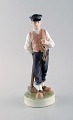 Royal Copenhagen porcelain figurine. Farmer / Guardian boy with lumber hammer. 
Model Number: 620.
