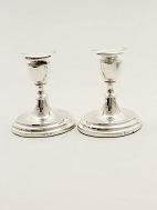 A pair of silver candlesticks sold