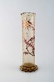 Tidlig Emile Gallé vase i klart matteret kunstglas. Overfang udskåret med 
motiver i form af blomster og blade. Kantet bund og munding. Emaljearbejde og 
forgyldt. Ca. 1885.