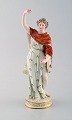 Meissen porcelain figurine. Woman in colorful dress with floral wreath in her 
hair. Ca. 1900.