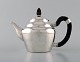 Early and rare Georg Jensen teapot in hammered silver with handle in ebony. 
Design number 28. Dated 1915-30.
