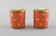 Bvlgari / Bulgari for Rosenthal. Two "Mano al vento" candle holders in 
porcelain. Orange glaze and gold decoration. Late 20th century.
