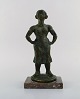 Eric Demuth, svensk billedhugger. Skulptur i bronze på marmor base. Kvinde med 
hænderne i siden. 1940/50