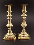 A pair of brass candlesticks on square foot