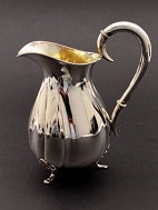 Curved silver jug on 3 legs