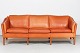 Danish ModernThree-seater sofa upholstered with cognac-coloredleather and with legs of ...