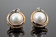 Ole Lynggaard; A pair of earclips of 14k gold and white gold with a diamond and 
a mabé pearl