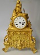 French 
gilt-bronze 
mantle clock, 
approx. 1830. 
Top figure in 
the form of 
young woman 
with a ...