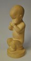 Danish artist 
(20th century): 
Sitting boy. 
Made of 
sandstone. 
Height .: 20.5 
cm. Stamped.