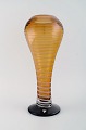 Helén Krantz for Orrefors. Large Fungi vase in amber colored mouth blown art 
glas with striped design. 1980s.
