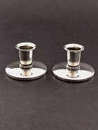A pair of small three-towered silver candlesticks