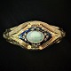 A 
bangle/bracelet 
made of 14k 
gold, set with 
an opal, 
diamonds and 
blue enamel. 
Around 1850. 
The ...