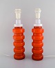 PO Ström for 
Alsterfors. Two 
table lamps in 
orange mouth 
blown art 
glass. Swedish 
design, ...