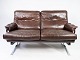 Two seater sofa upholstered with patinated brown leather and frame in metal, designed by Arne ...