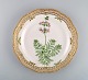 Royal Copenhagen Flora Danica tallerken i gennembrudt porcelæn med håndmalede 
blomster og gulddekoration. Modelnummer 20/3526. Dateret 1958.
