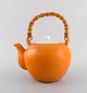 Kenji Fujita for Tackett Associates. Porcelain teapot with bamboo handle. 
Beautiful orange glaze. Dated 1953-56.
