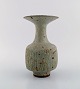 Lucie Rie (f. 1902, d. 1995, østrigsk-født britisk keramiker. Stor modernistisk 
unika vase i glaseret keramik / stentøj. Smuk glasur i grå nuancer. Rillet 
korpus. Trumpet formet munding. Eget værksted, ca. 1970.
