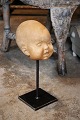 Bust of 
children's head 
in terracotta 
standing on 
iron foot, part 
of the figure 
"Nina on the 
...