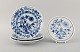 Stadt Meissen Blue Onion pattern. Trivet and three plates. Mid-20th century.
