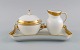 Royal Copenhagen White Dagmar. Sugar bowl and creamer on serving tray in 
porcelain with hand-painted gold decoration. 1930s.
