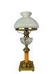Kerosene lamp of brass with shade of white opaline glass and stem of orange glass from around ...