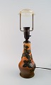 Ipsens enke, Danmark. Bordlampe i glaseret keramik med håndmalet bladværk. 
Modelnummer 95. 1940