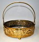 Brass fruit 
bowl with glass 
insert, WMF, 
approx. 1900, 
Germany. With 
handle. The 
sides decorated 
...