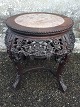Small round side table with rich carvings in hardwood and with plate in variegated marble. ...