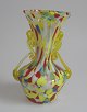 Italiensk vase, 
i flerfarvet 
glas, med hanke 
i gult glas. 
20. årh. 
Venedig. H.: 15 
cm.