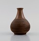 European studio ceramicist. Vase in glazed ceramics with grooved body. Beautiful 
glaze in brown shades. Dated 1964.
