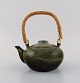 Chinese teapot 
in glazed 
stoneware with 
wicker handle. 
Beautiful 
speckled glaze 
in dark green 
...