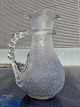 Kande I glas 
med flettet 
hank. "Ishylde" 
bag hanken. H. 
25 cm