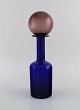 Otto Brauer for 
Holmegaard. 
Vase / bottle 
in blue 
mouth-blown art 
glass with 
purple ball. 
...